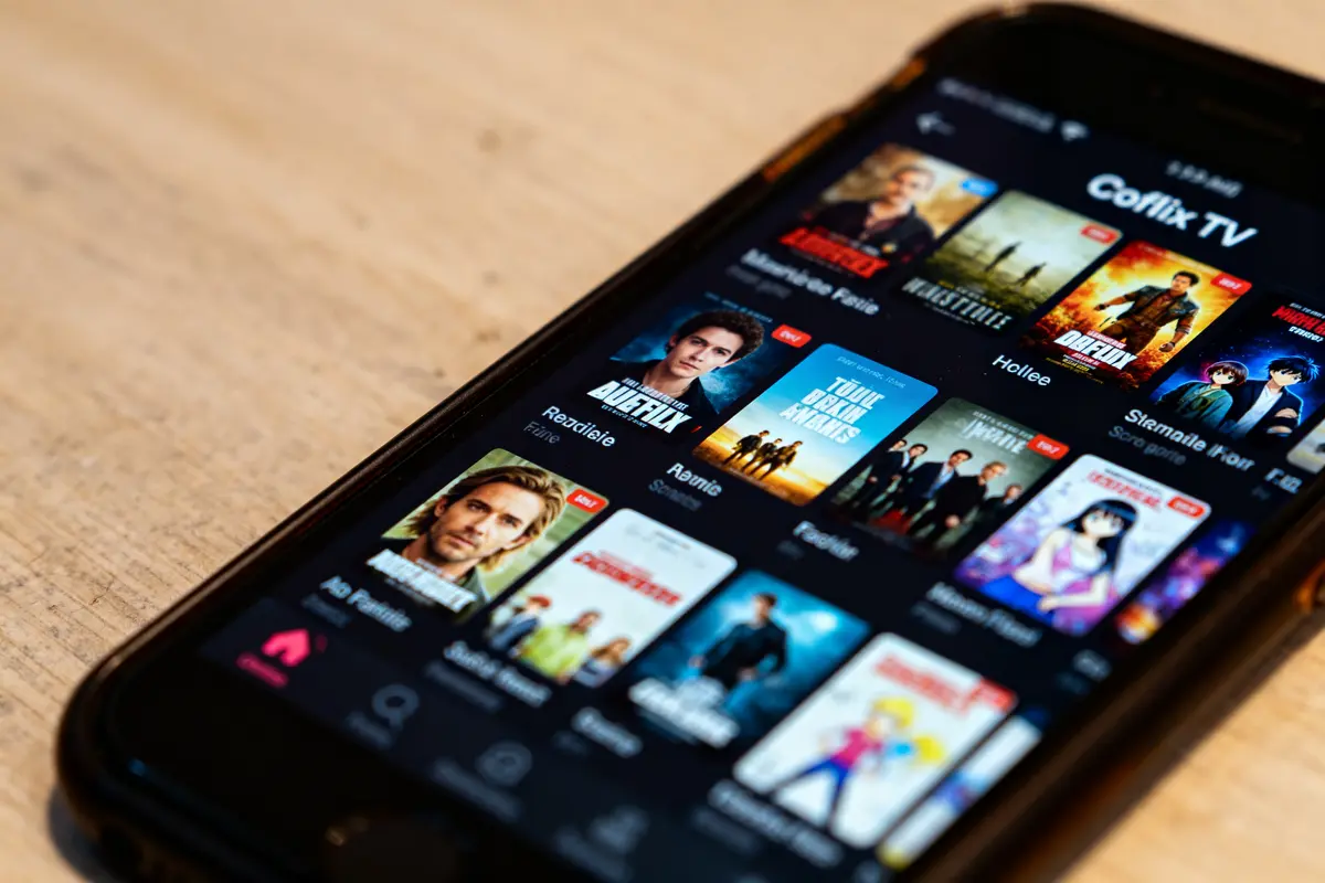 Application Coflix TV affichée sur smartphone avec miniatures de films et séries populaires