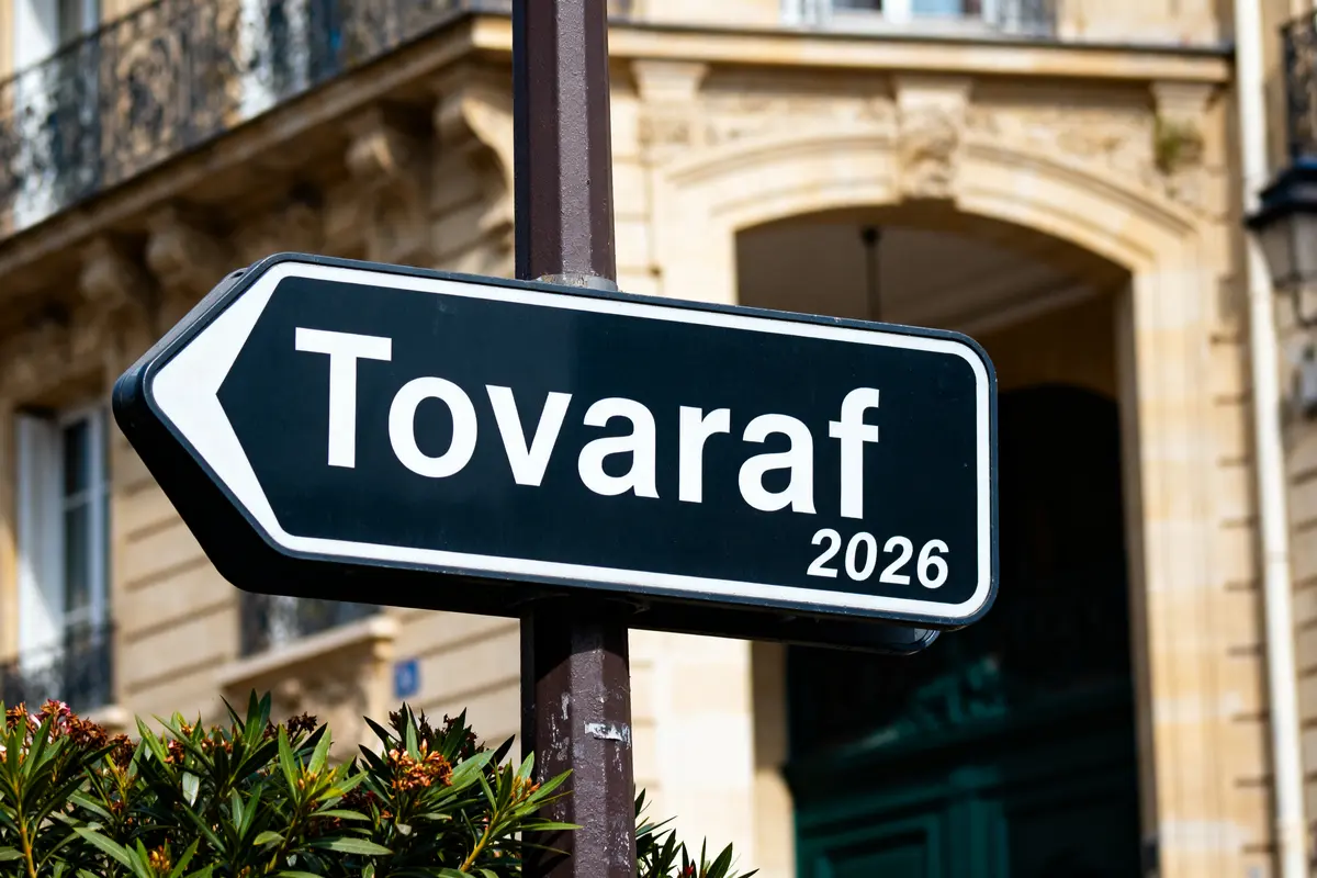 Panneau directionnel indiquant Tovaraf 2026 devant un bâtiment historique en arrière-plan